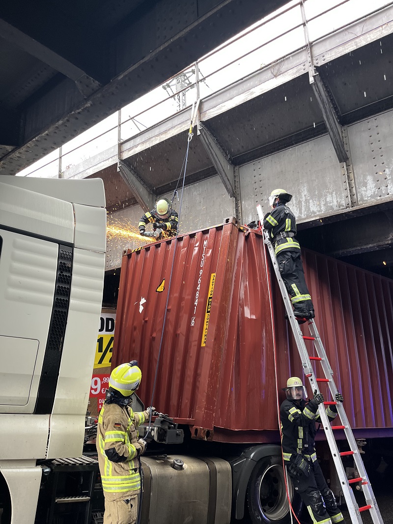 Einsatzkräfte arbeiten auf dem Dach des Containers